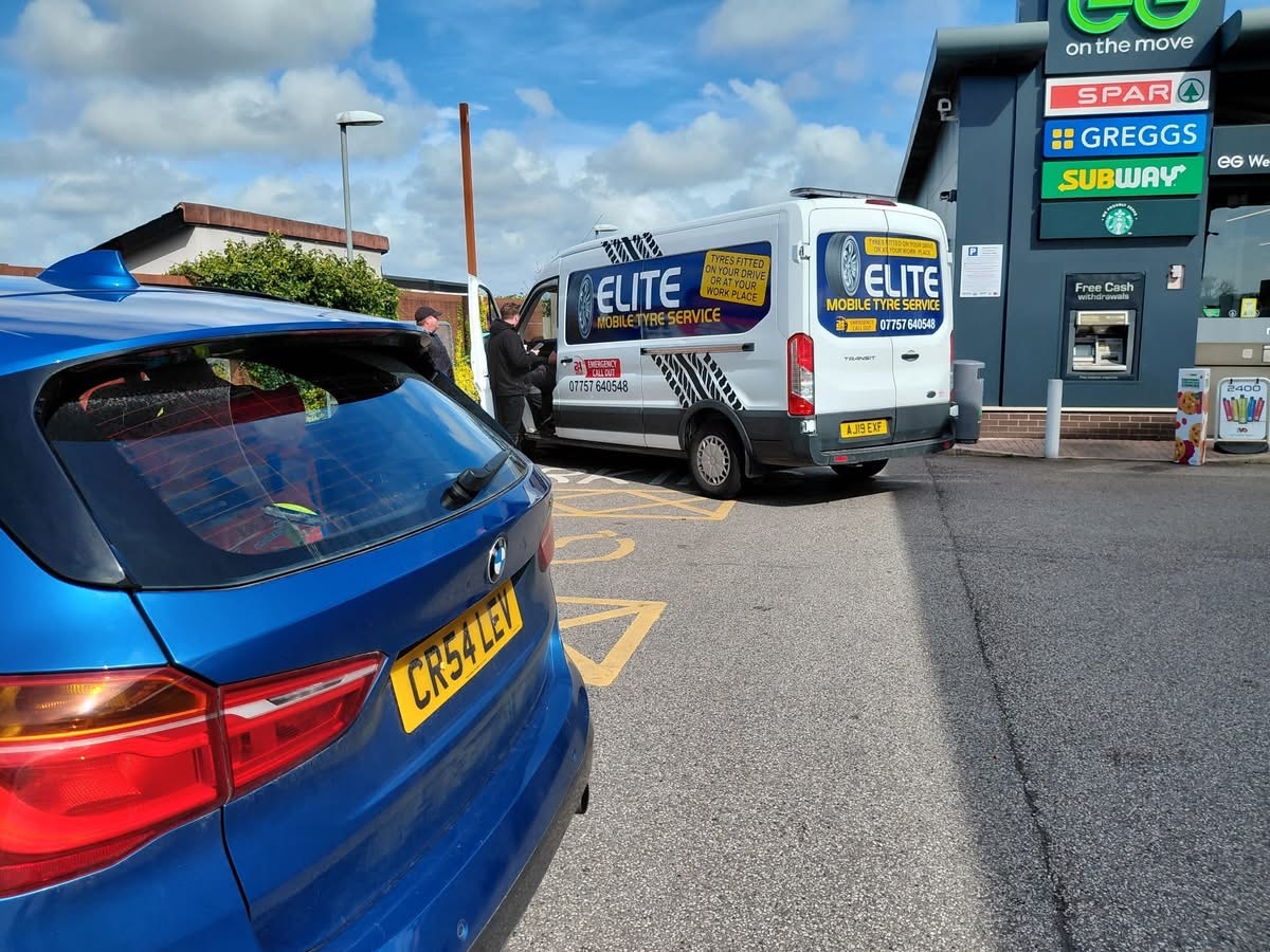 Mobile tyre fitting in Yorkshire — Elite Mobile Tyre Service van fitting new tyres for a BMW at a service station car park