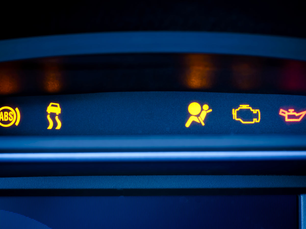 Car dashboard showing warning lights.