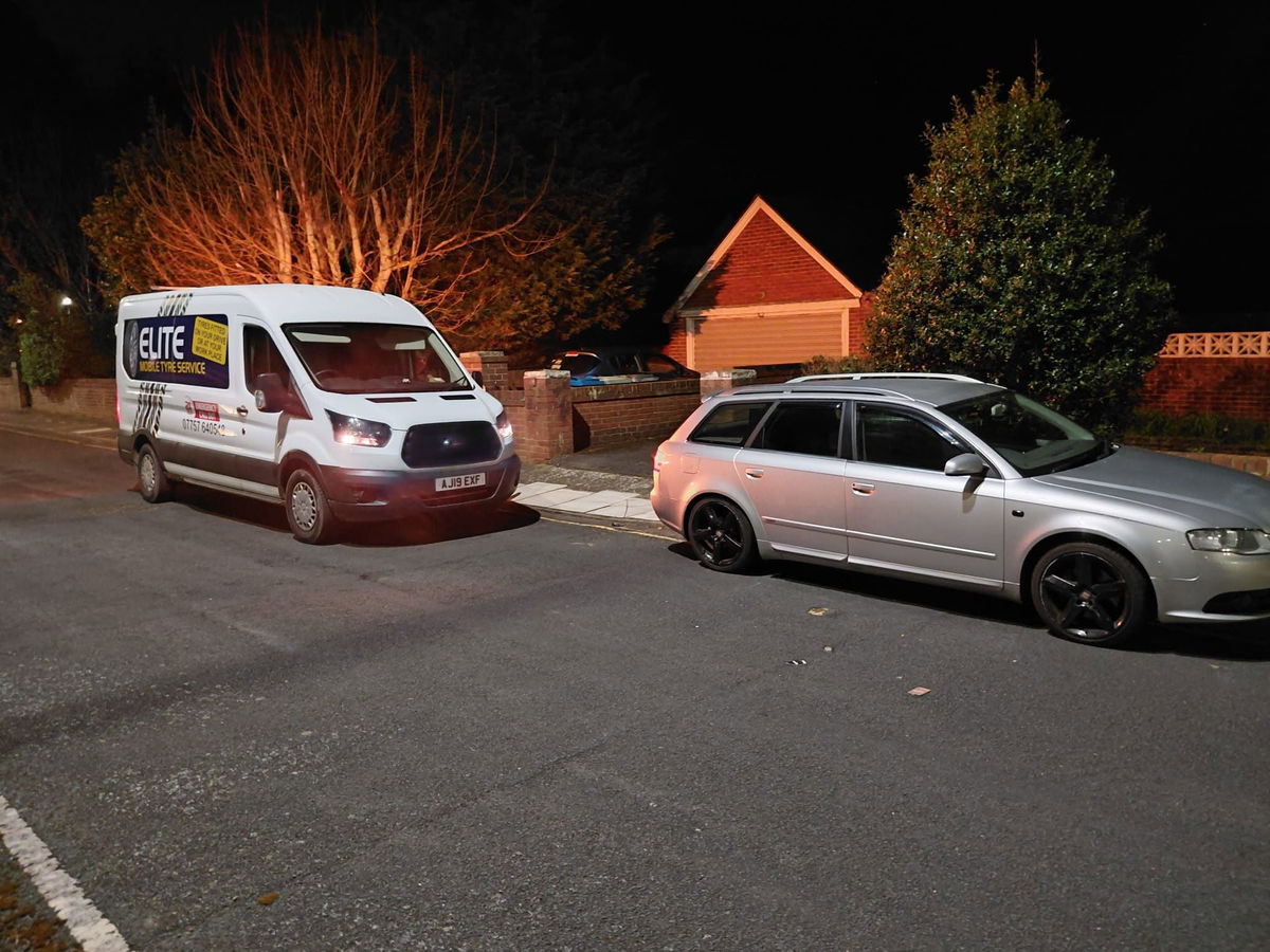 Elite van attending a broken down car at night.