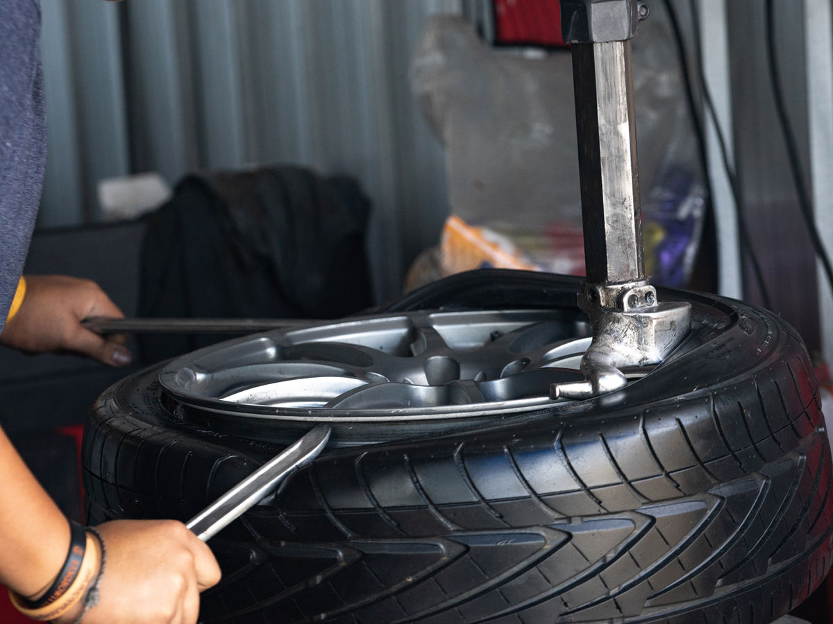 Mechanic installing a tyre on to a wheel.