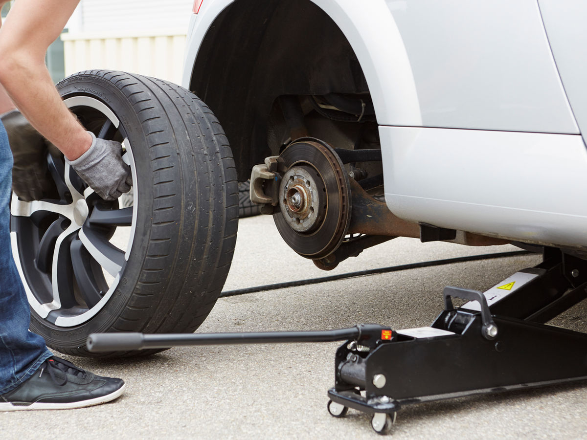 Roadside tyre change with a jack near the car.